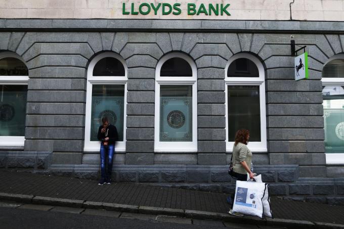 Une femme marche après la banque britannique, Lloyds Bank, sur l'île de Guernesey
